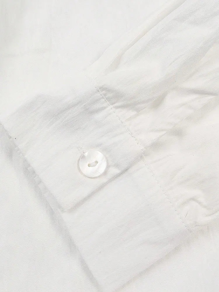 Close-up of a white quilted fabric with a button