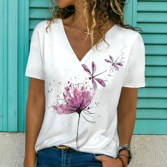 Person wearing a white t-shirt with purple floral designs against a turquoise background