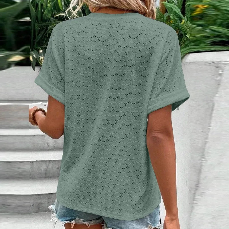 Person wearing a green textured t-shirt with a blurred background