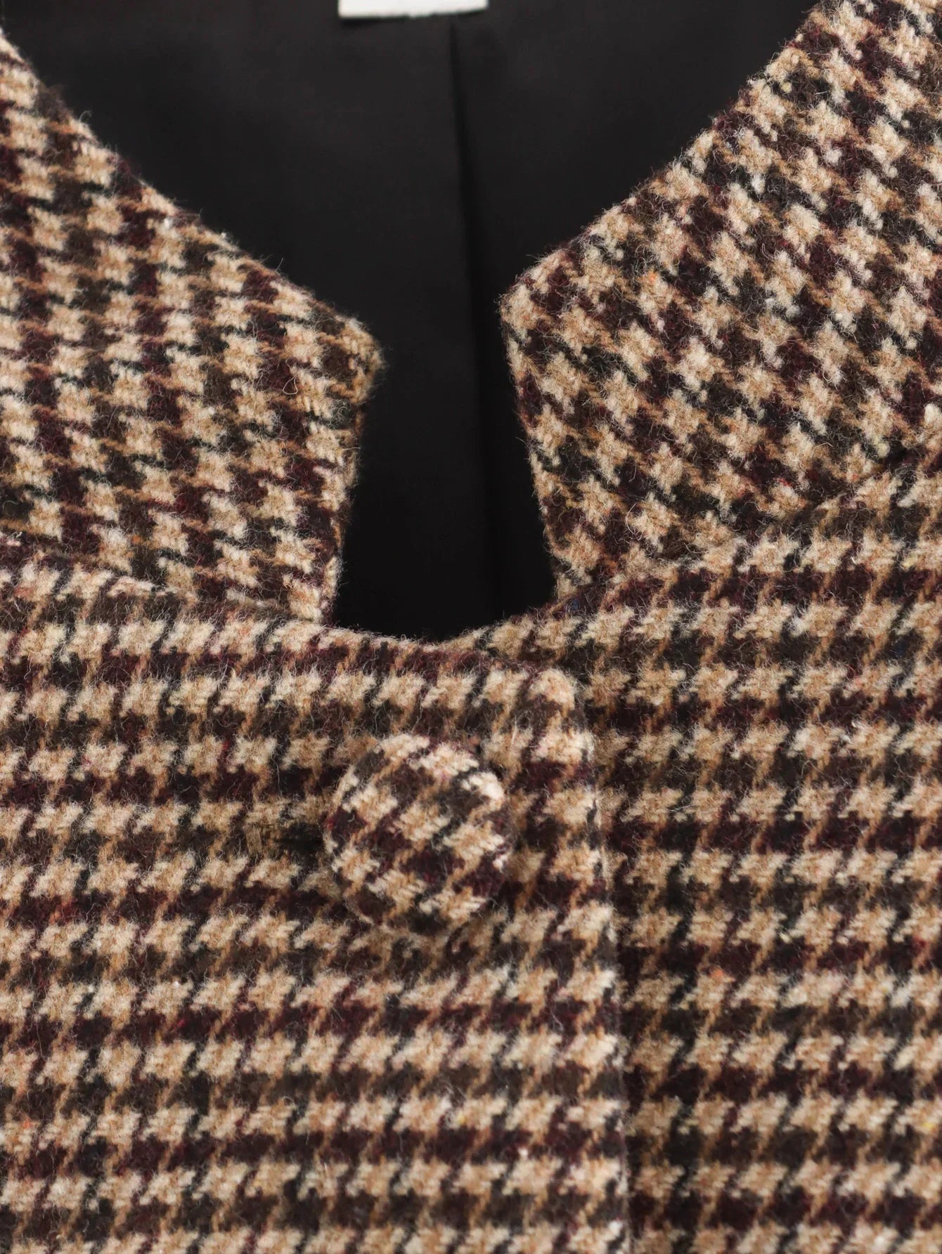 Close-up of a houndstooth patterned vest with a black bow tie.
