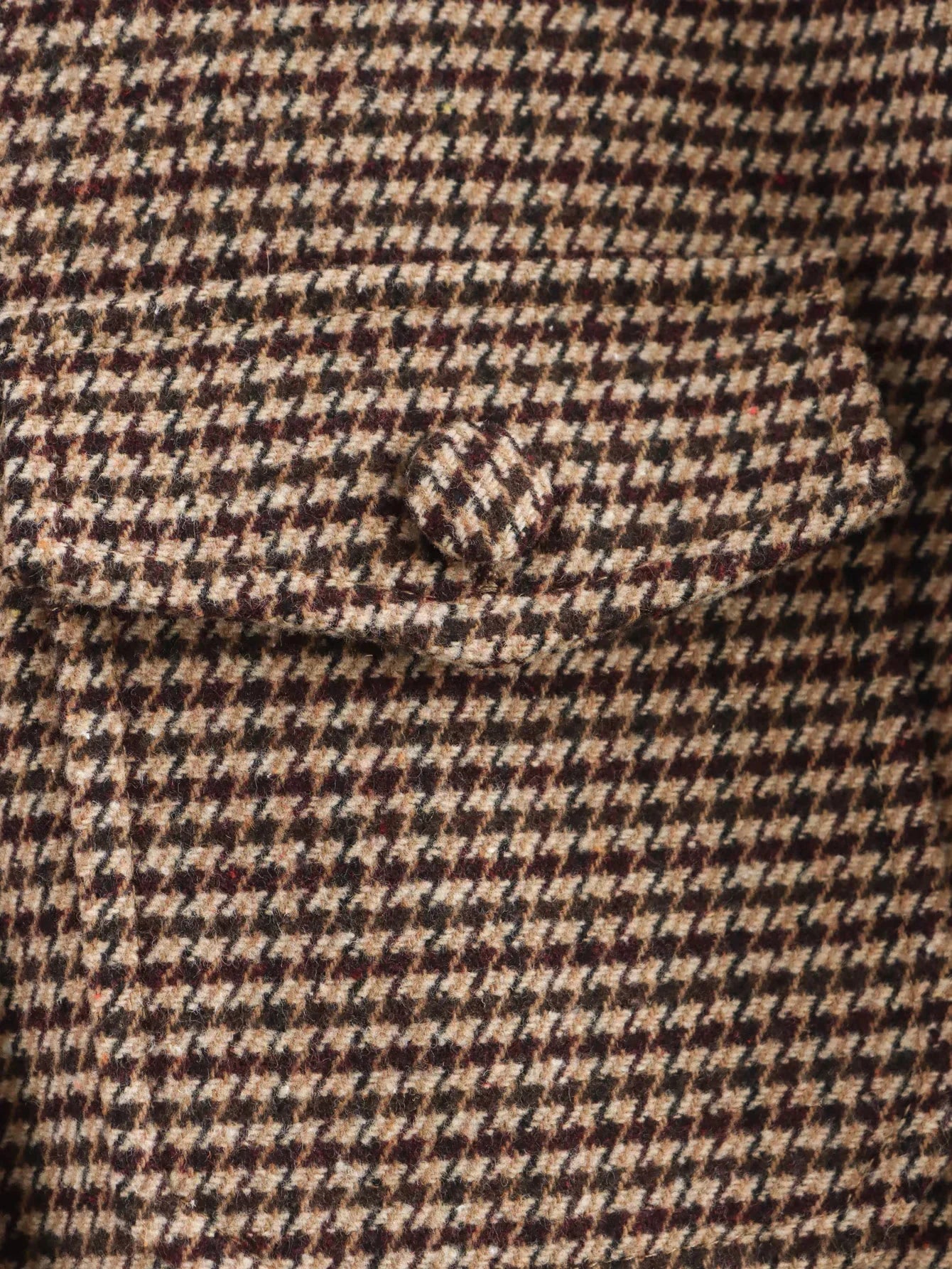 Close-up of a houndstooth patterned fabric with a pocket detail.