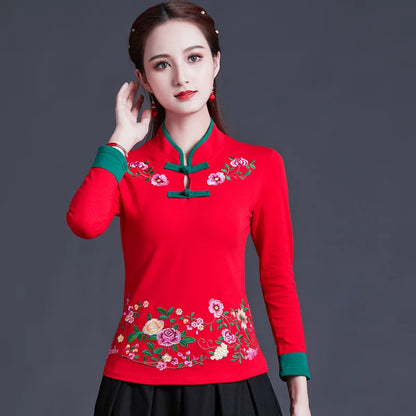 Woman wearing a red traditional outfit with floral embroidery on a dark background