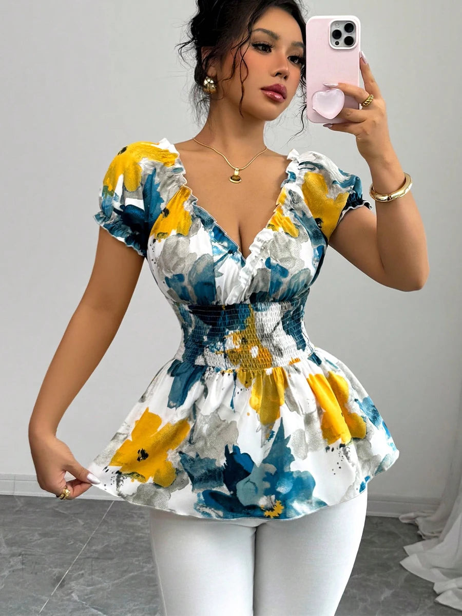 Woman taking a mirror selfie wearing a colorful floral dress with a plain background