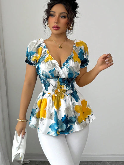 Woman wearing a colorful floral dress against a plain background