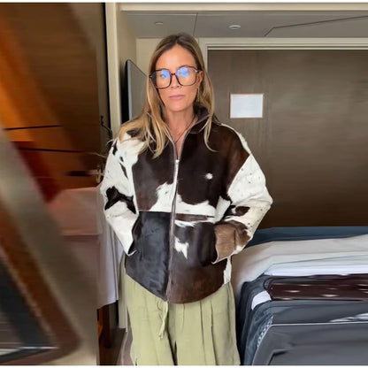 Person wearing a cow print jacket in an indoor setting