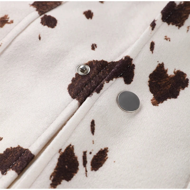 Close-up of a coat with brown abstract pattern and silver buttons on a white background