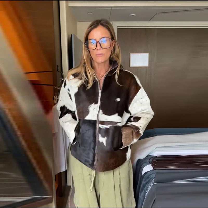 Person wearing a cow print jacket in an indoor setting