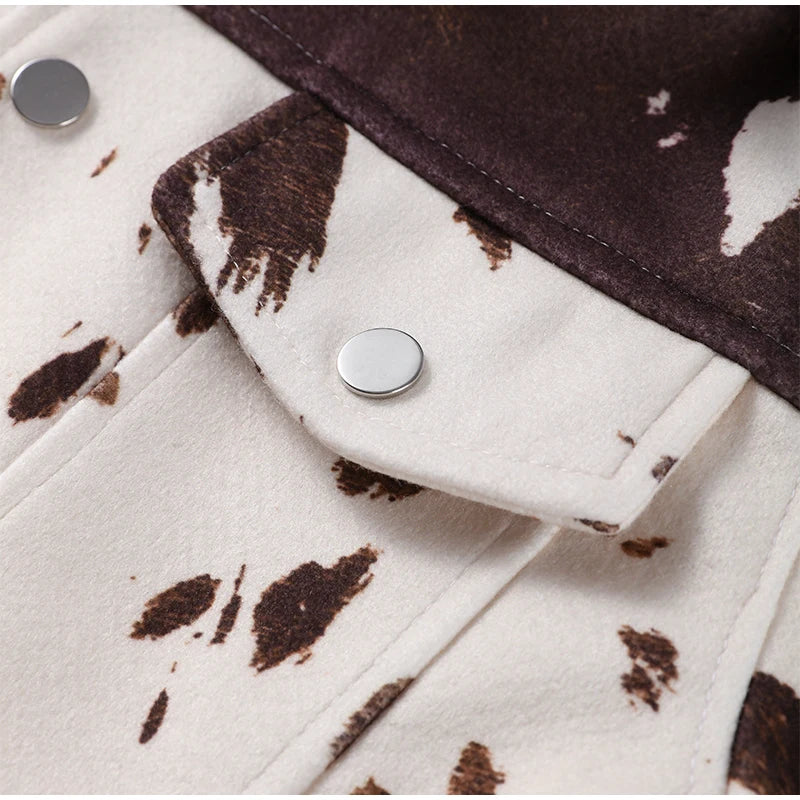 Close-up of a jacket with cow print pattern and button details.