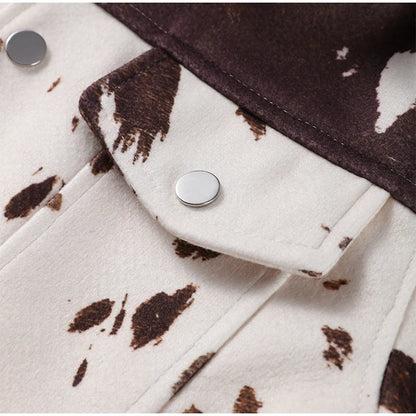 Close-up of a jacket with cow print pattern and button details.