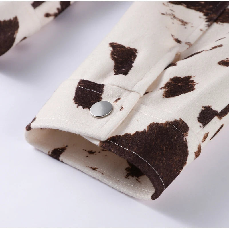 Close-up of a fabric with brown and white cow print pattern on a white background