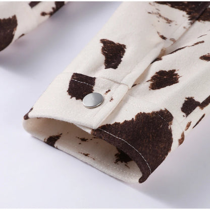 Close-up of a fabric with brown and white cow print pattern on a white background