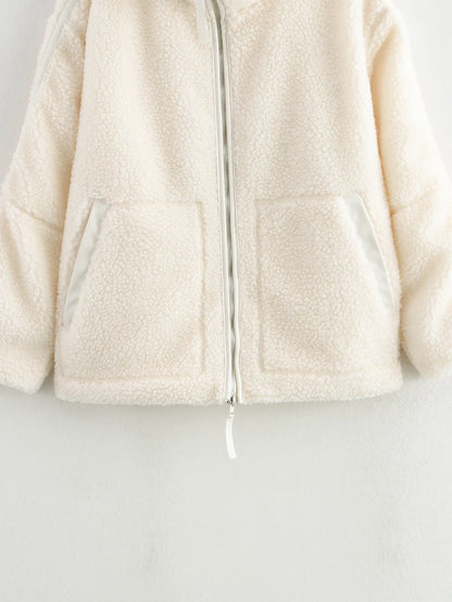 Close-up of a cream-colored fleece jacket on a light gray background
