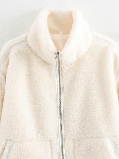 Close-up of a cream-colored fleece vest with a zipper on a light gray background