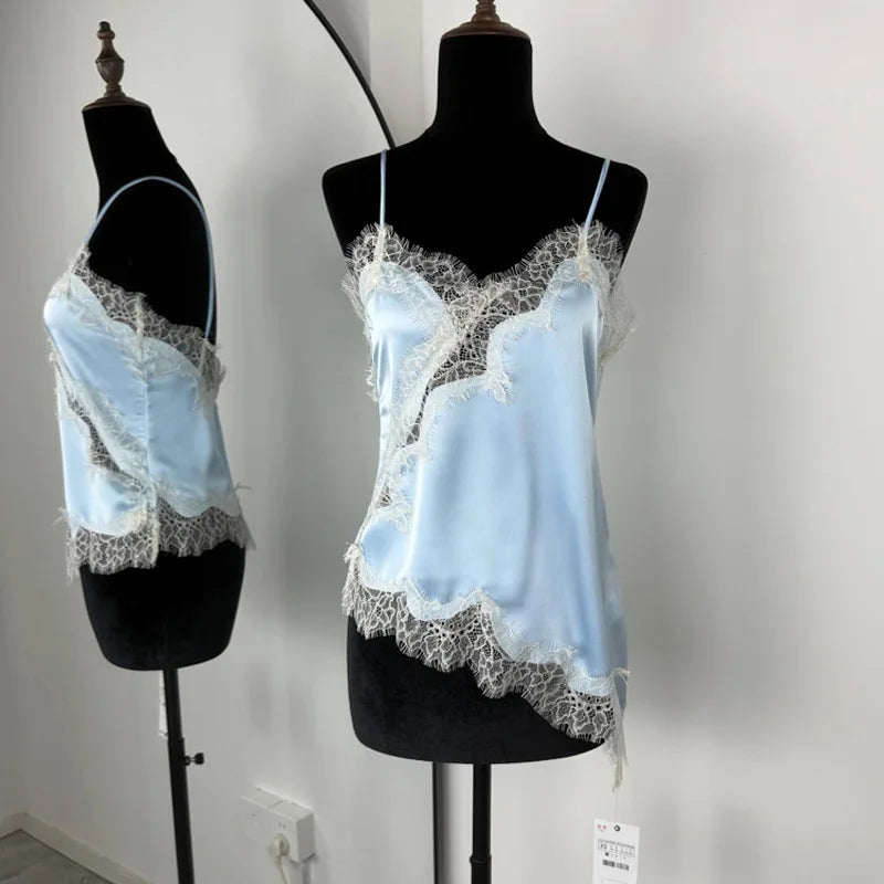 Light blue lace-trimmed top on a black mannequin against a white wall.