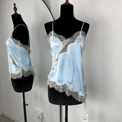 Light blue lace-trimmed top on a black mannequin against a white wall.