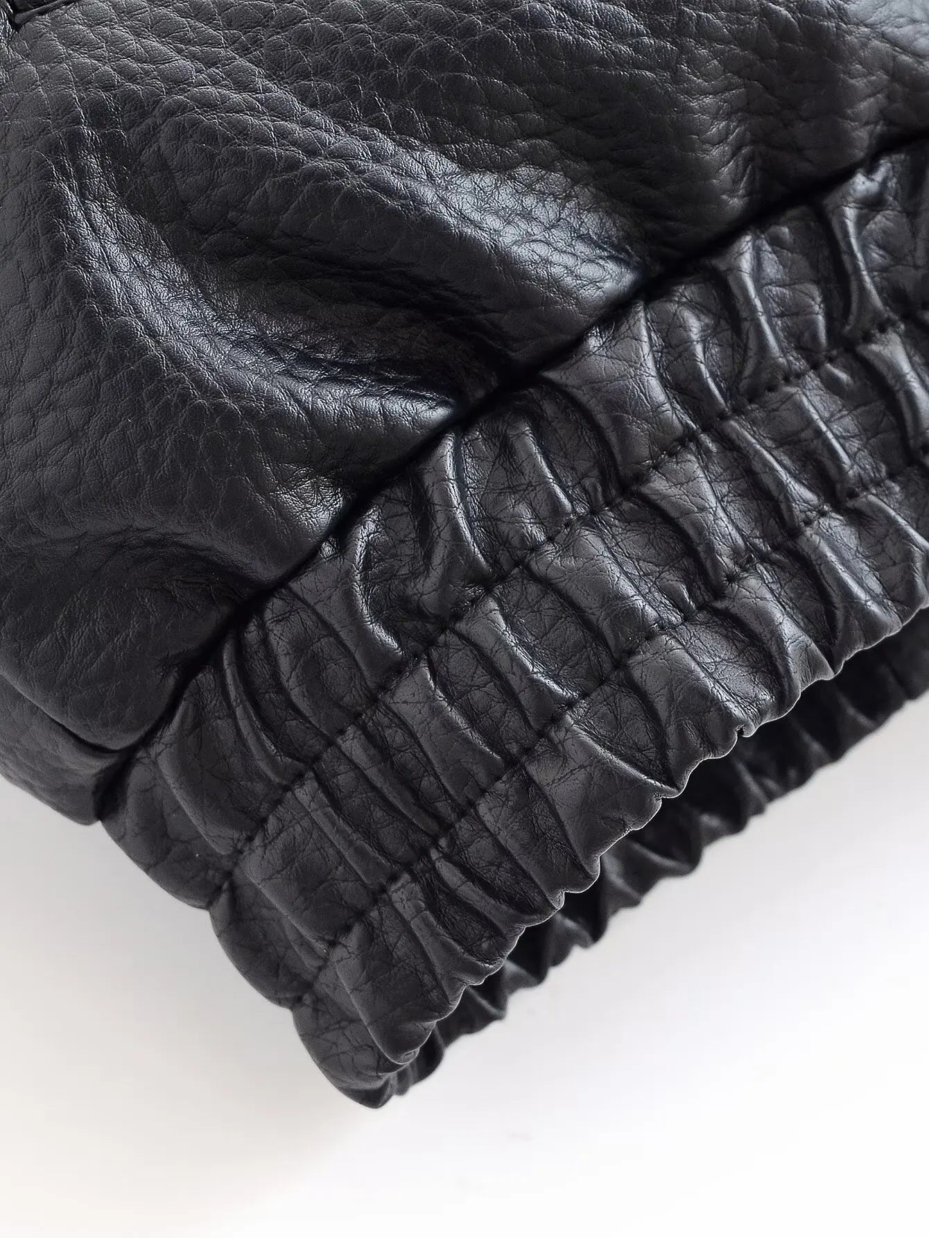 Close-up of a textured black blanket on a white background