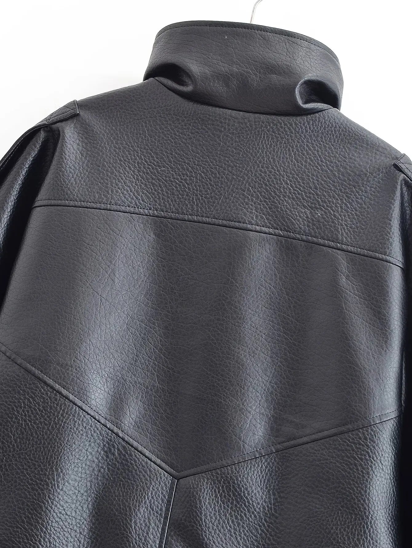 Close-up of a black leather jacket on a white background