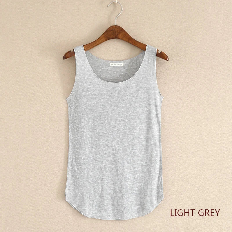 Light grey tank top on a wooden hanger against a beige background
