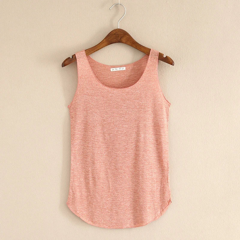 Pink tank top on a wooden hanger against a beige wall
