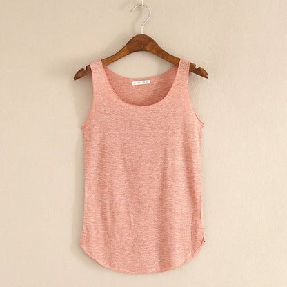 Pink tank top on a wooden hanger against a beige wall