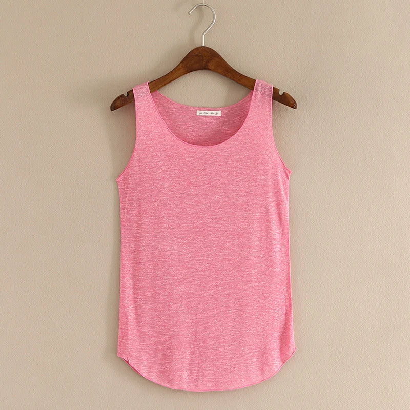 Pink tank top on a wooden hanger against a beige wall