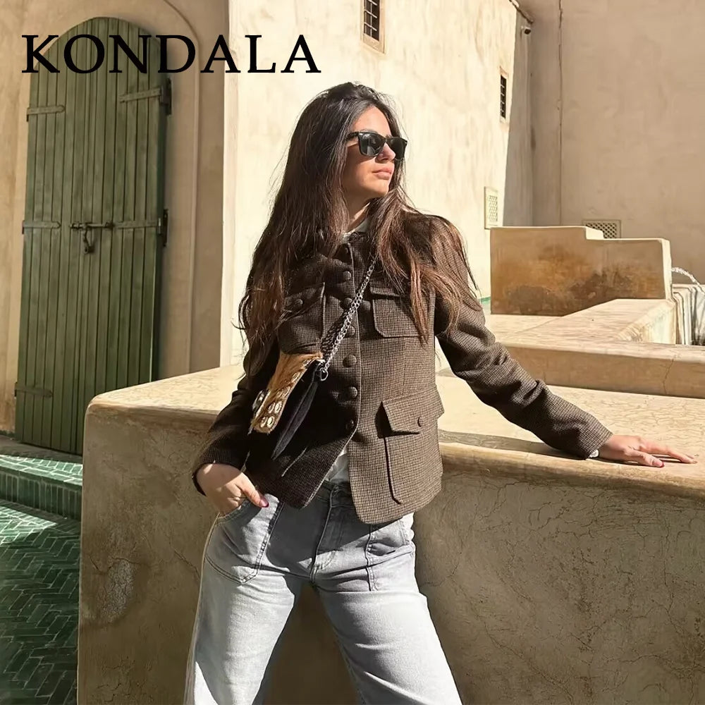 Woman in a brown jacket and sunglasses standing on steps with 'KONDALA' branding.