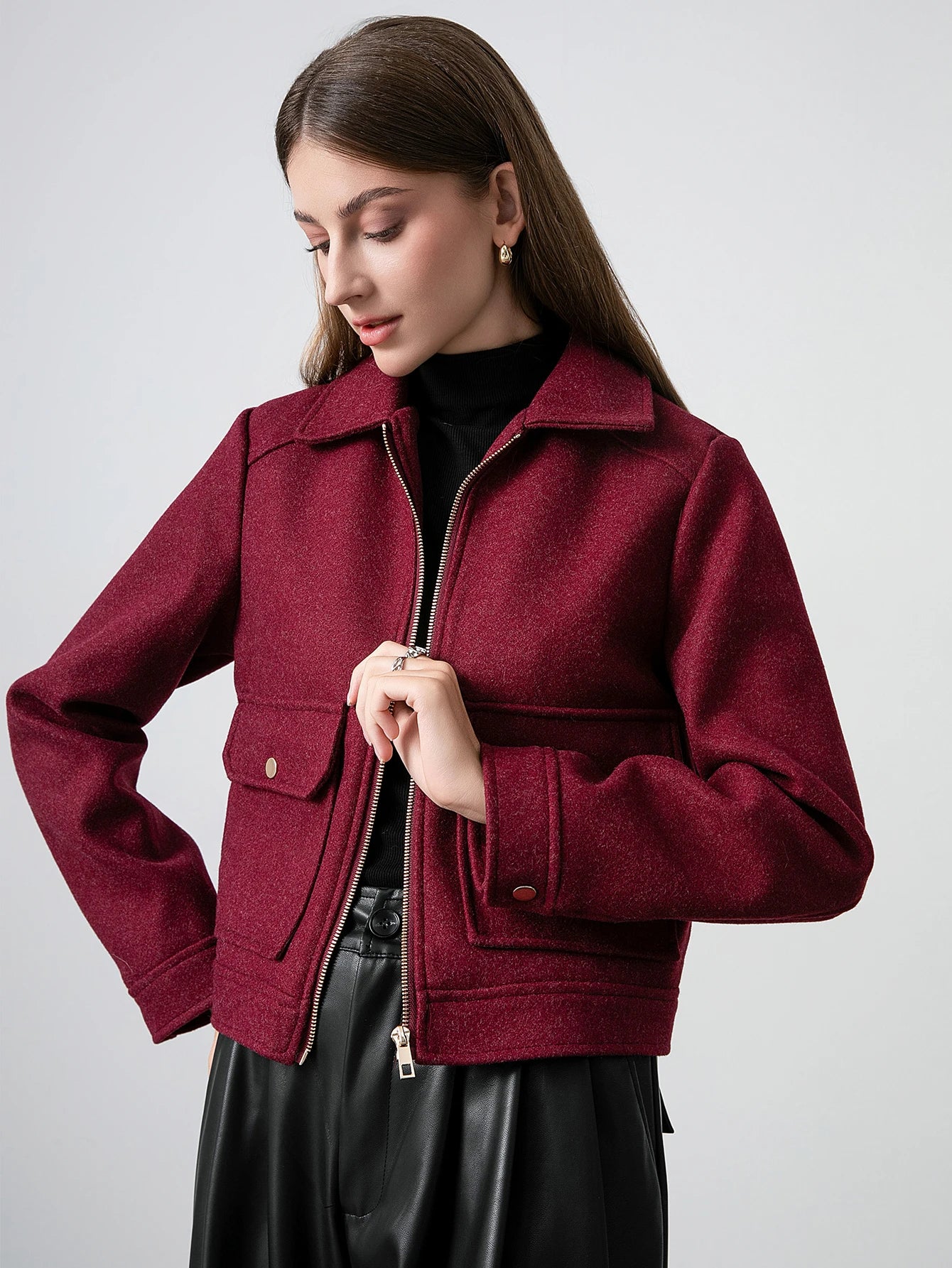 Woman wearing a burgundy jacket on a plain background