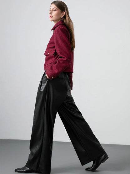 Woman wearing a red jacket and black pants against a plain background