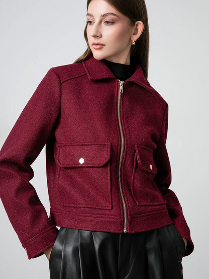 Woman wearing a burgundy jacket with a plain background