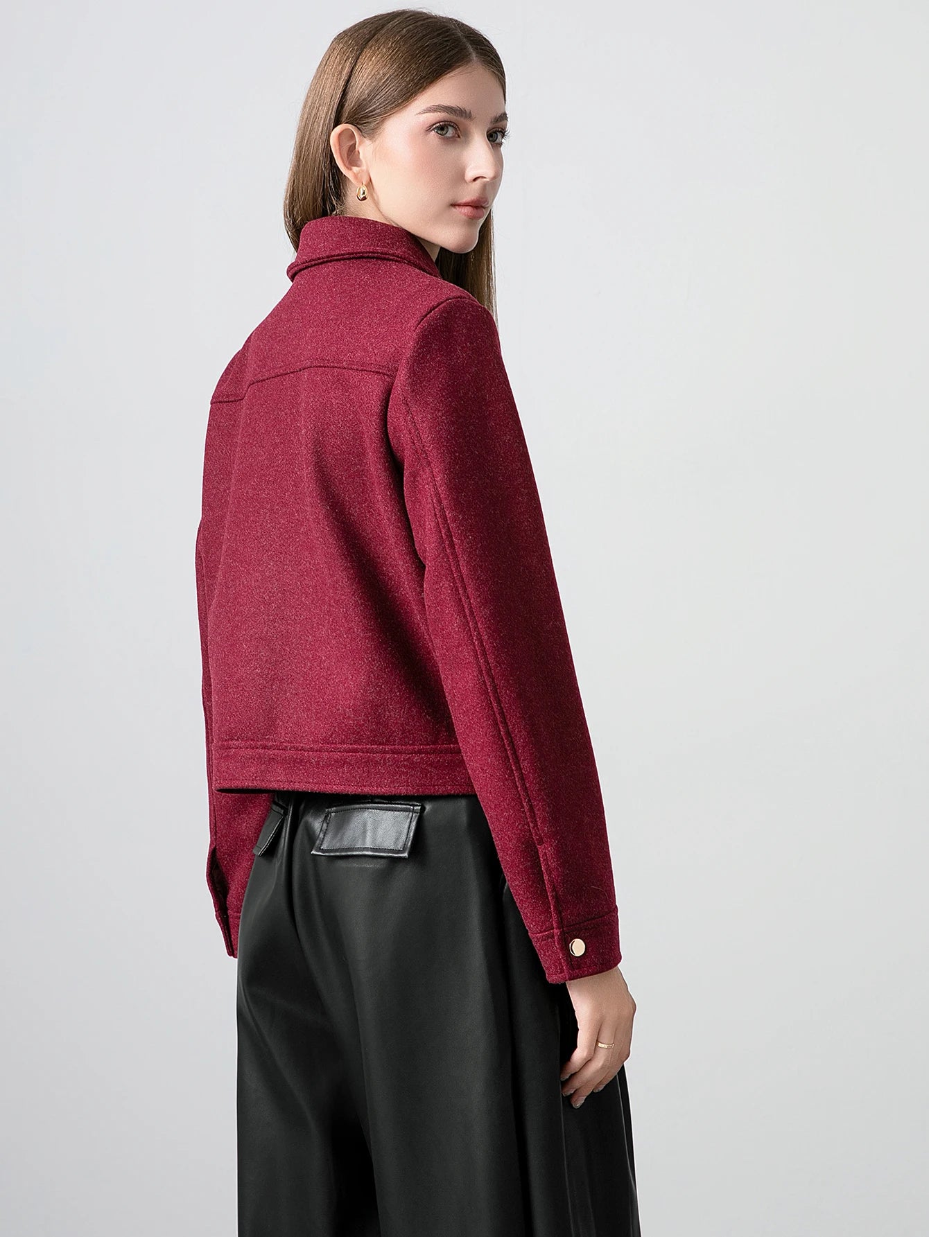 Woman wearing a red jacket on a plain background