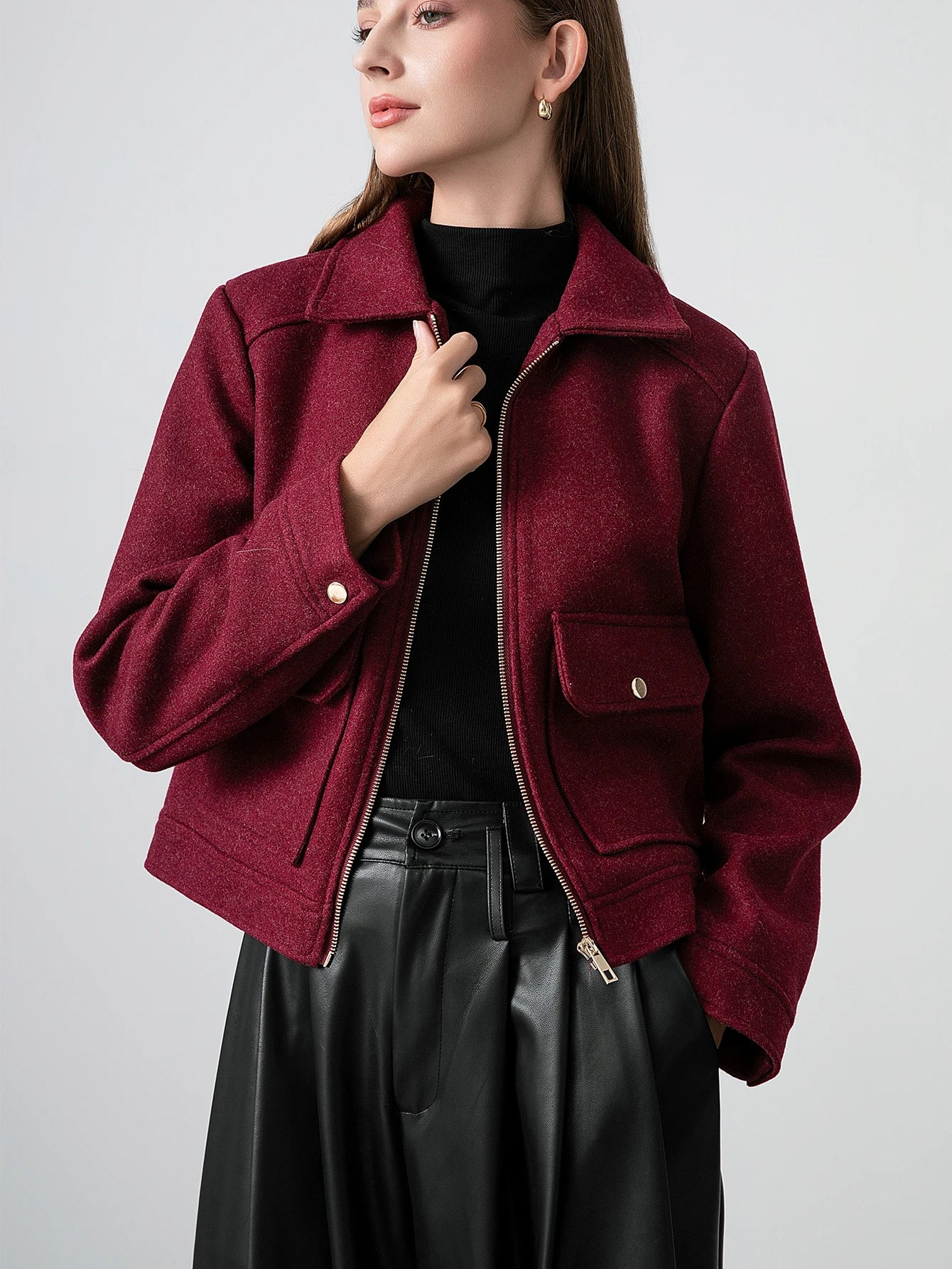 Woman wearing a burgundy jacket with a plain background