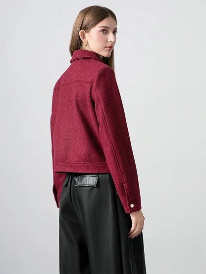 Woman wearing a red jacket and black pants on a plain background