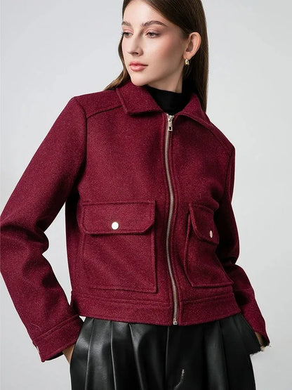 Woman wearing a burgundy jacket with a white background