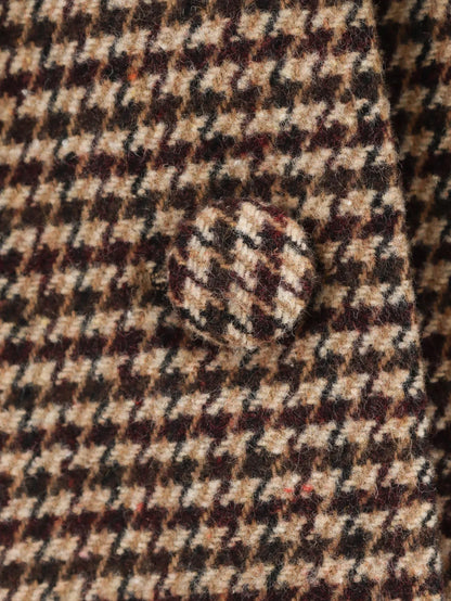 Close-up of a houndstooth patterned fabric with a button.