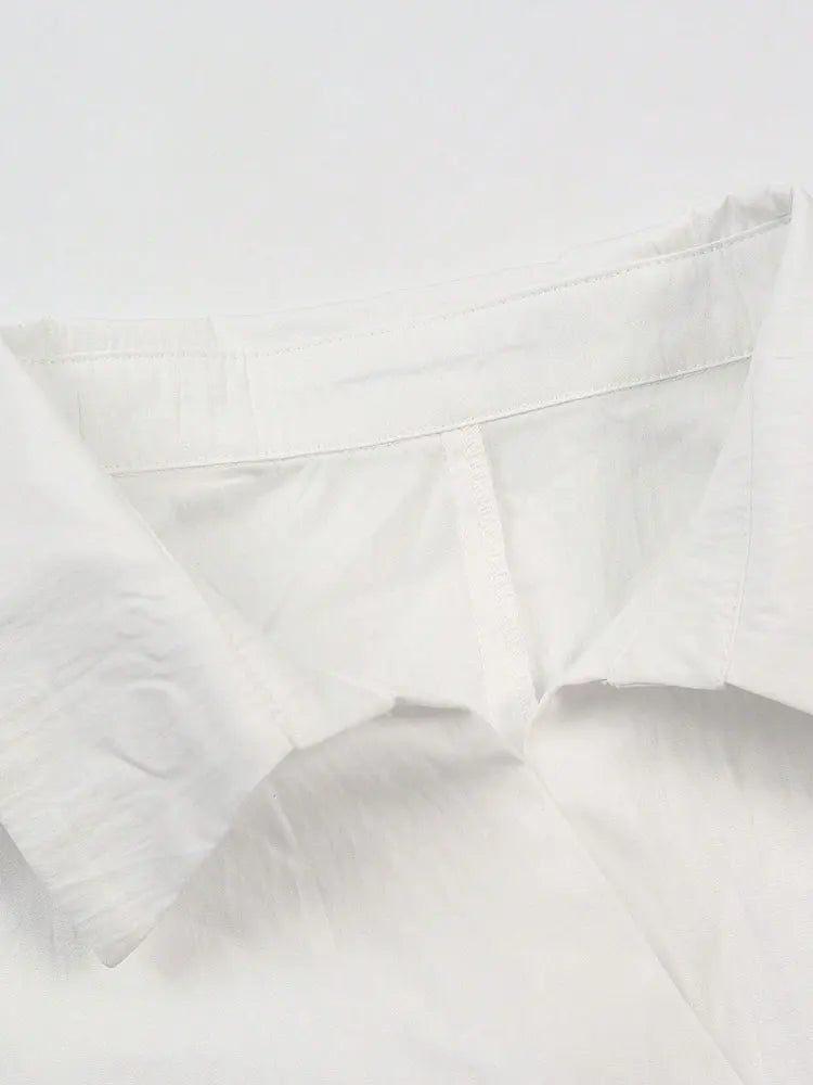 Close-up of a white pillow with visible stitching on a white background