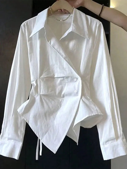 White shirt with unique design on a hanger against a neutral background