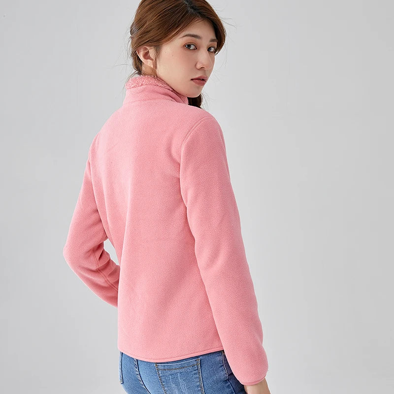 Person wearing a pink fleece jacket on a gray background