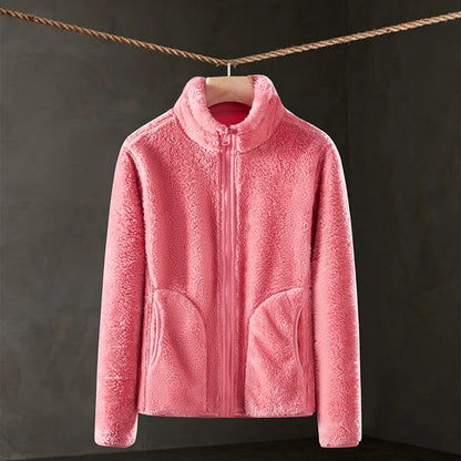 Pink fleece jacket hanging on a clothesline against a dark background