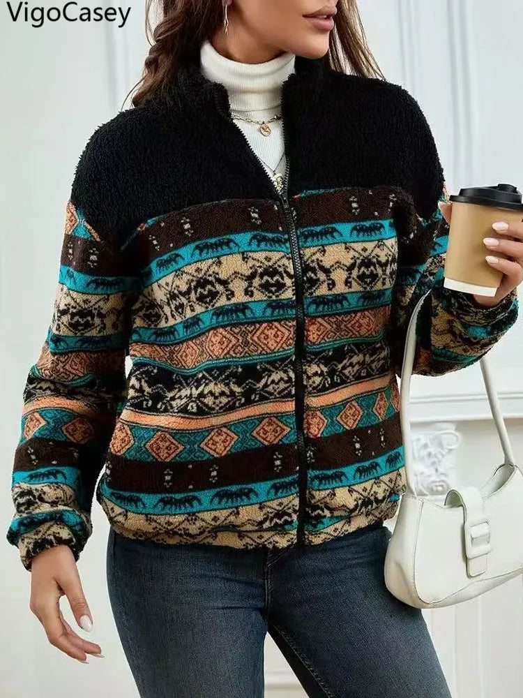 Person wearing a patterned jacket holding a coffee cup indoors