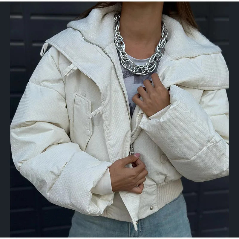 Person wearing a white puffer jacket with a dark background