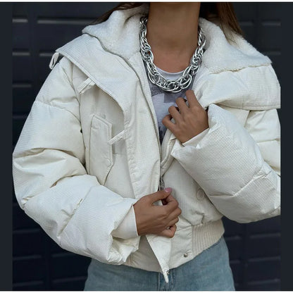 Person wearing a white puffer jacket with a dark background