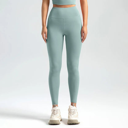 Person wearing light green leggings and a matching top on a white background