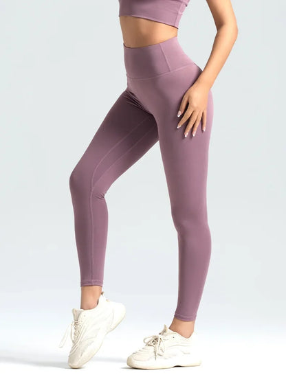 Person wearing mauve leggings and a matching top on a white background