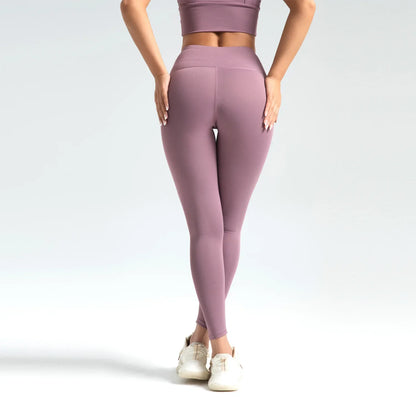 Person wearing mauve leggings and top on a light gray background
