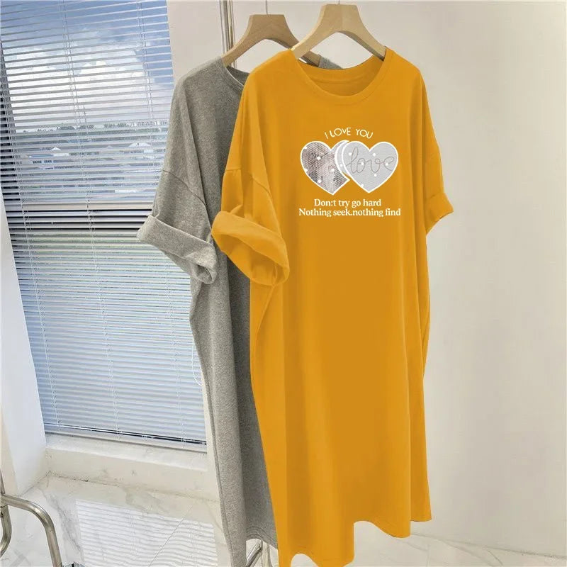 Yellow t-shirt with graphic design and text on a hanger against a window background