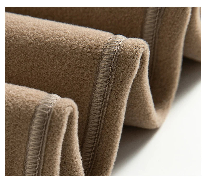 Close-up of brown fabric with a visible seam on a white background