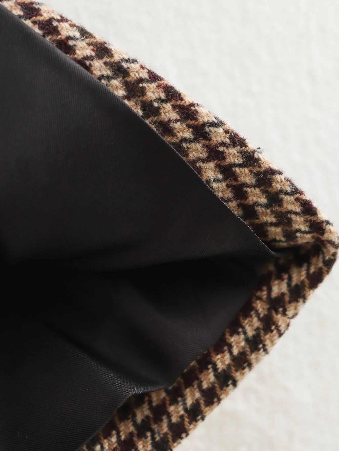 Close-up of black fabric with a houndstooth pattern on a white background