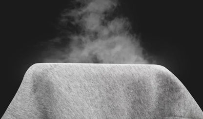 Steaming hot dog bun with steam rising against a black background