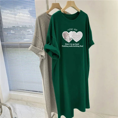 Green t-shirt with printed design on a hanger against a window background