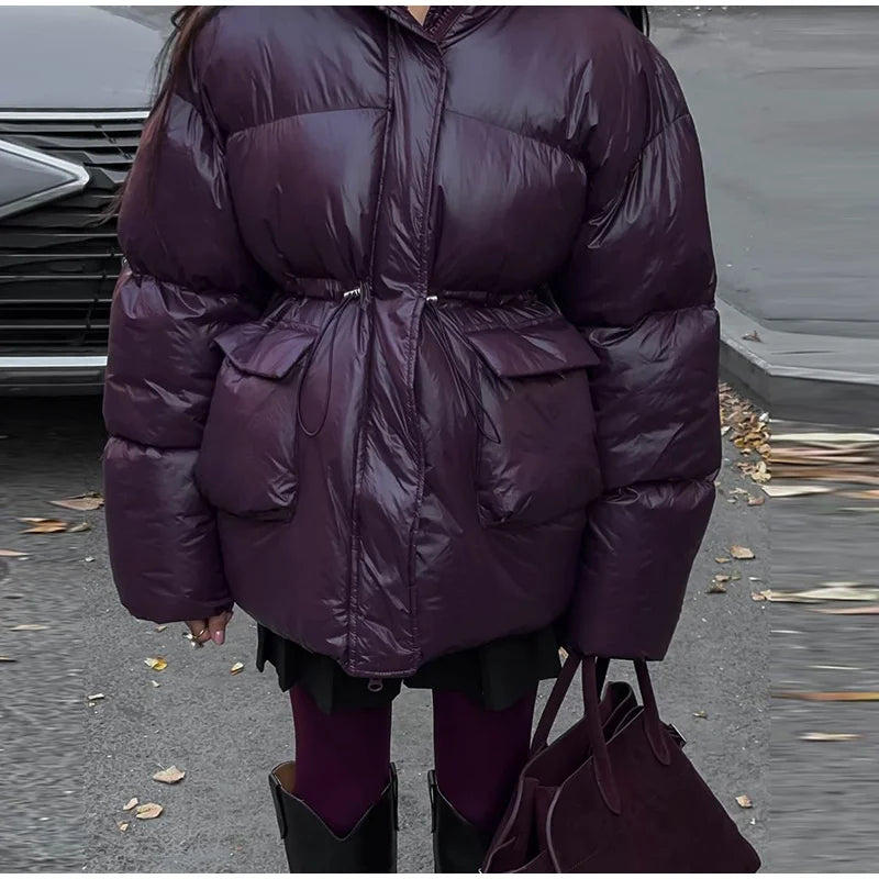 Person wearing a purple puffer coat in an outdoor setting